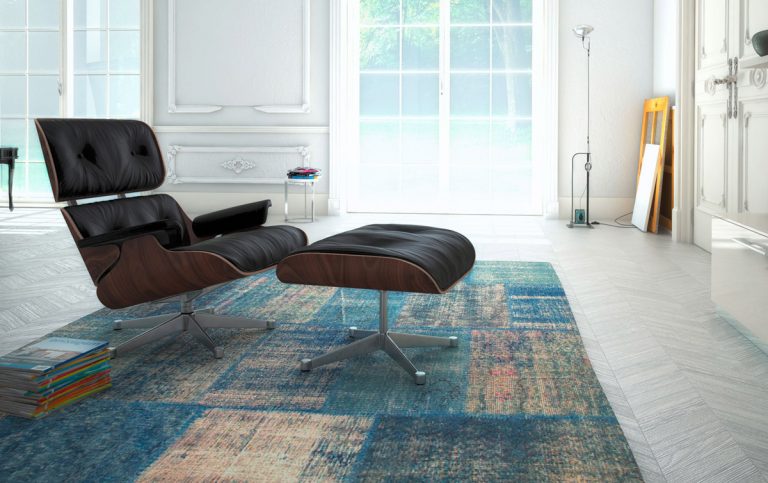 Sessel mit Holz, schwarzem Leder und Metallgestell steht auf einem Teppich in Blautönen