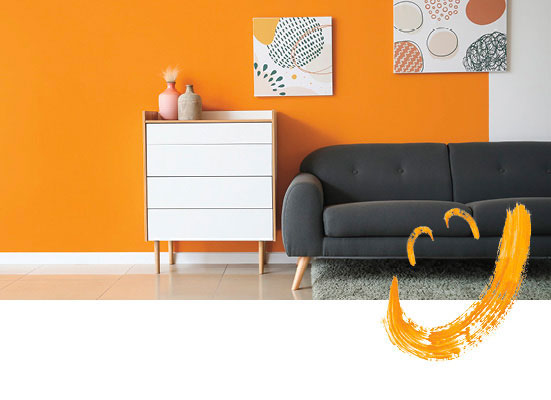 Orangene Wand mit weißem Schränkchen und schwarzem Sofa
