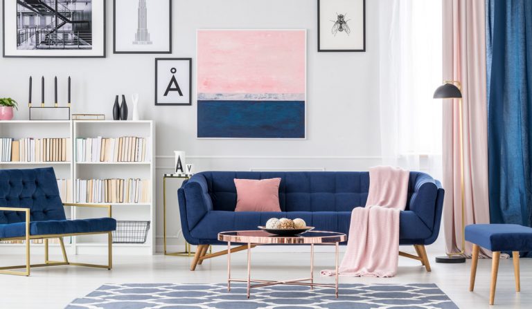 Wohnraum mit blauem Sofa und Bildern an der Wand