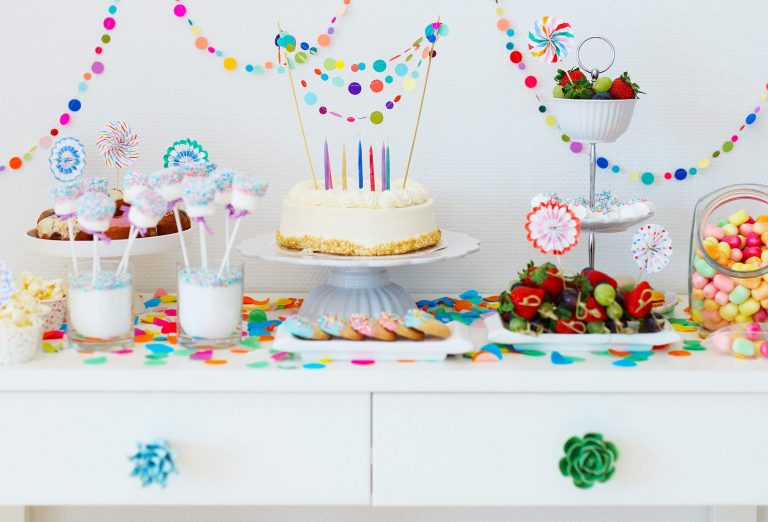 Buffet aus bunten Süßigkeiten mit Torte, Cake-Pops, Obst, Kaubonbons und Donuts bunt dekoriert