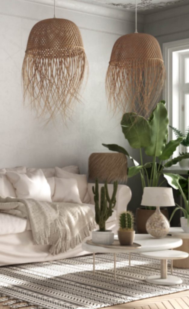 Zimmer mit Bast-Lampen, hellem Sofa und Zimmerpflanzen