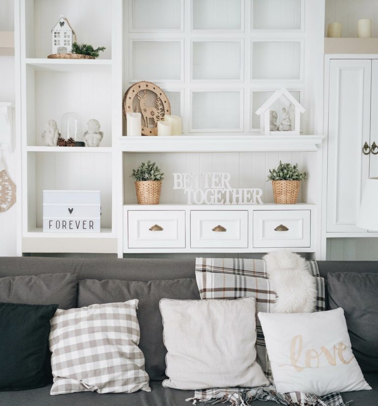 Wohnraum im Landhausstil mit weißen Möbeln und grauem Sofa