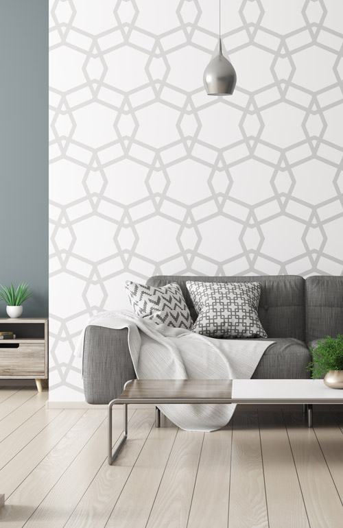 graues Sofa vor weißer Wand mit grauem Muster