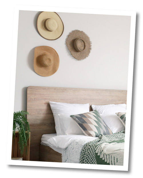 Hüte als Wanddekoration über einem Bett