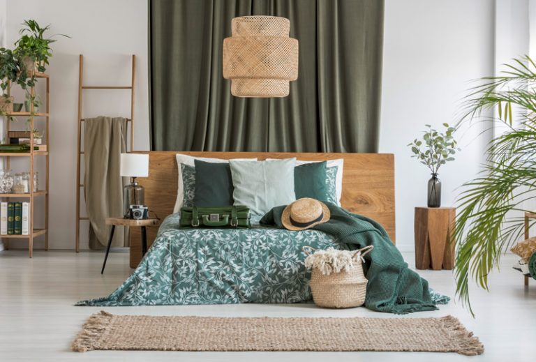 Schlafzimmer mit Holz und Decken und Kissen in Olivgrün