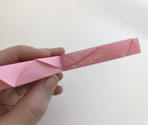 Gefaltetes rosa Papier mit Kleber