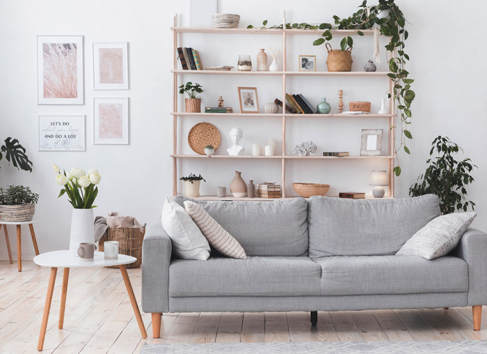 Stilvolles Wohnzimmer mit moderner heller Couch und heimischen Pflanzen
