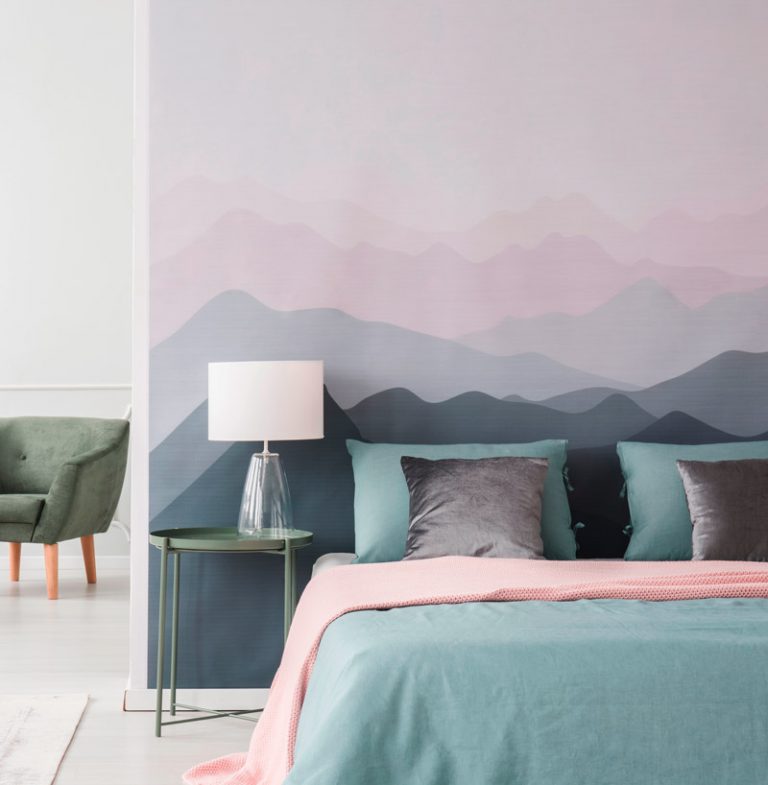 Bett vor Wand mit Landschaft in Pastellfarben