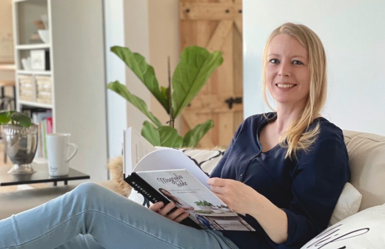 Interior-Designerin Elly sitzt auf ihrem Sofa mit einem Buch
